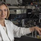 Laura in lab coat in front of tech equipment
